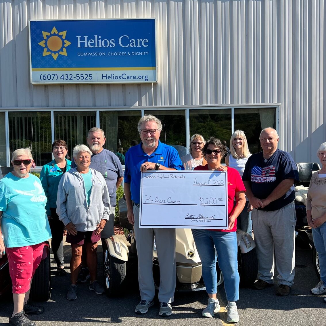 Group of people holding a check and smiling at the camera