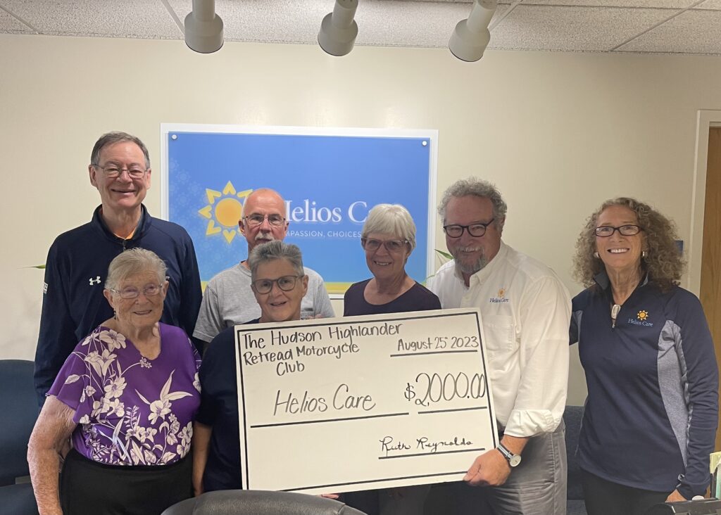 Motorcycle club presenting check to Helios Care staff