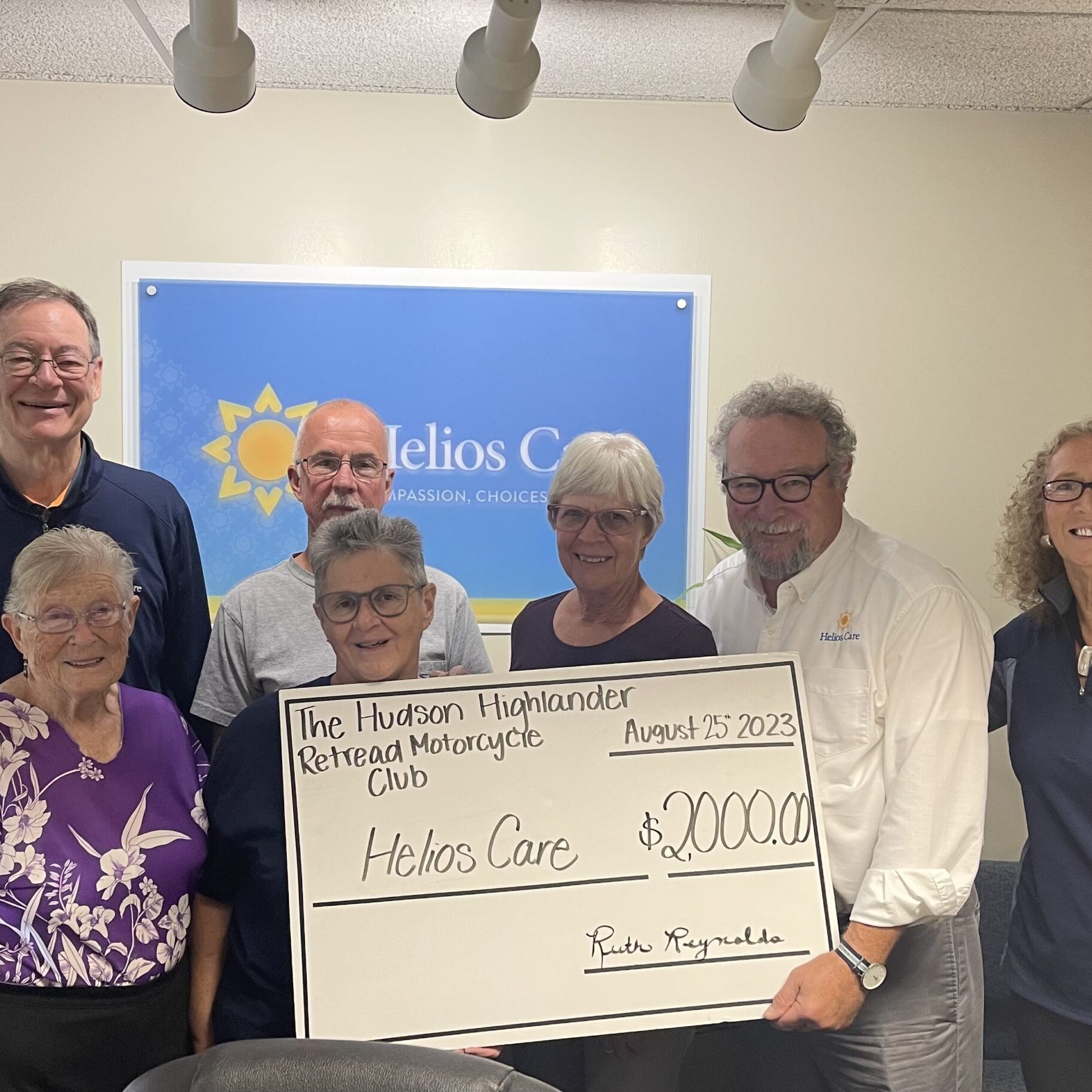 Motorcycle club presenting check to Helios Care staff
