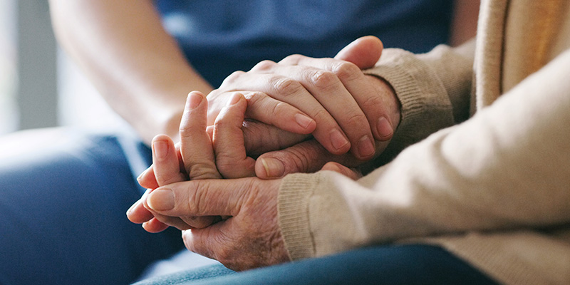 Patient Centered Care close up of two people holding hands in comfort