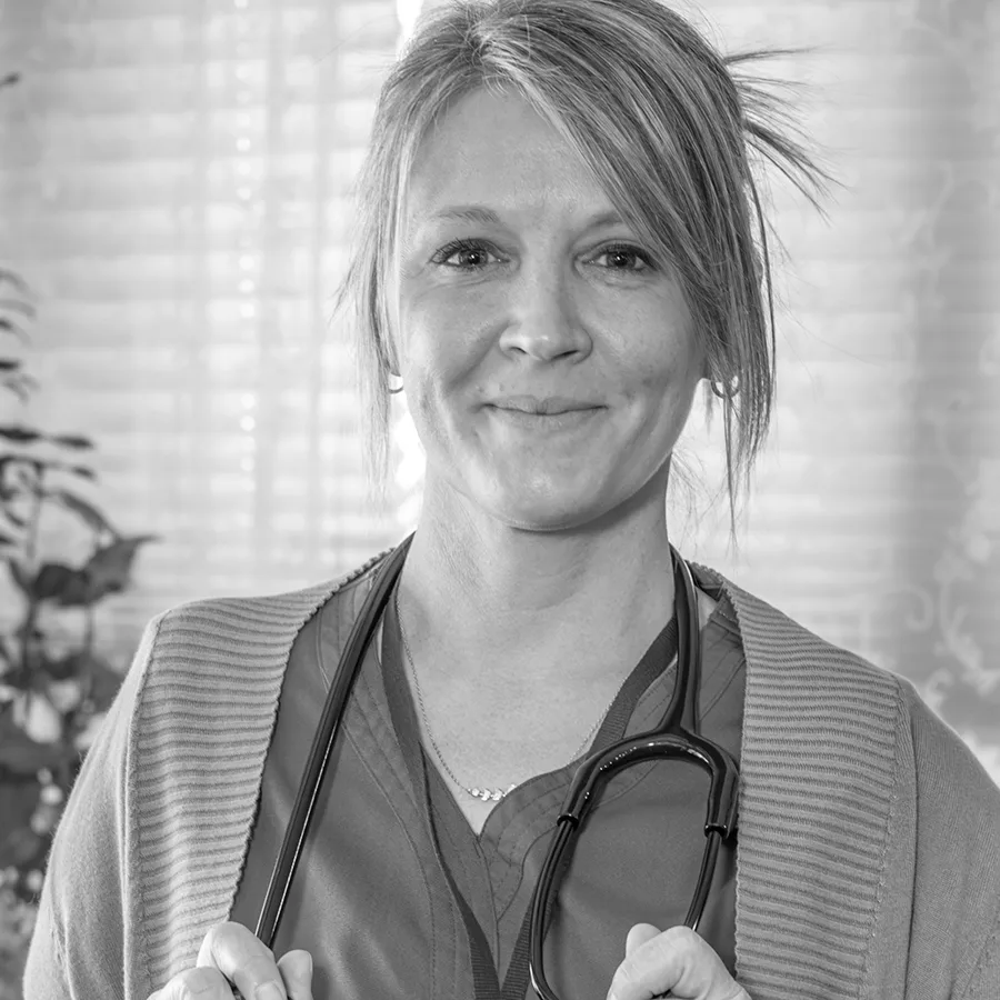 Home Health Nurse holding stethoscope and looking at camera