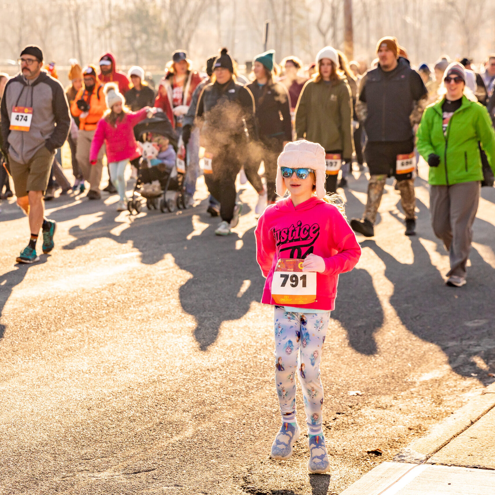 Little girl standing among crowd of walkers