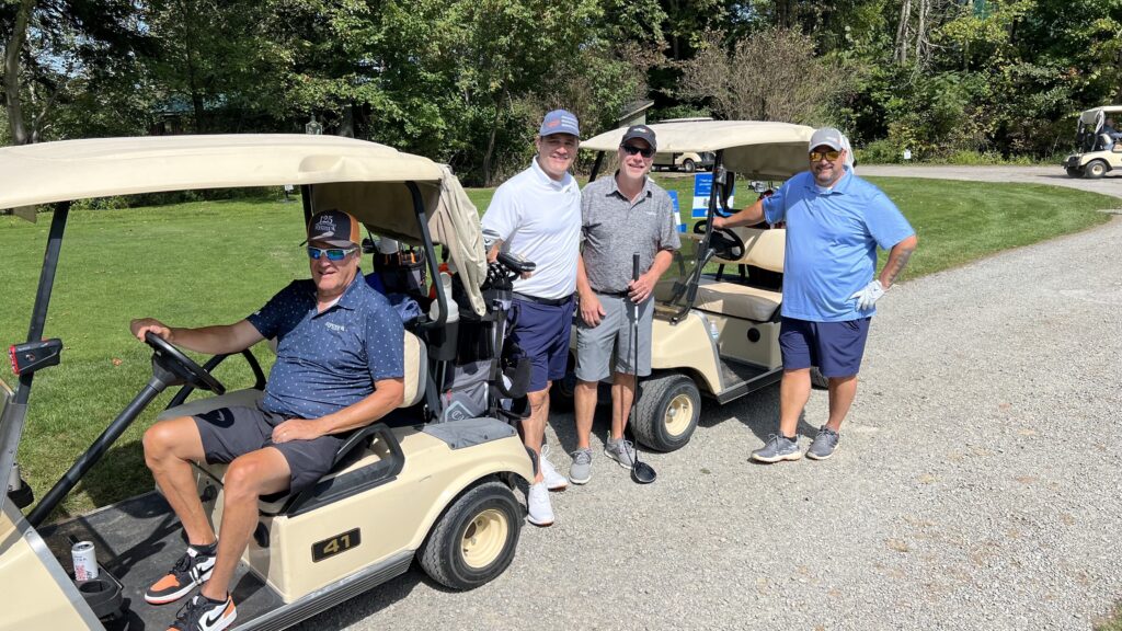 Four men smiling at the camera