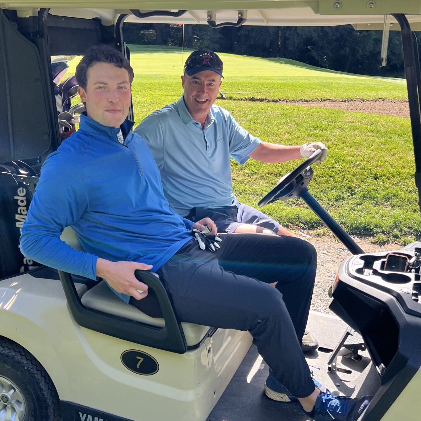 Two people sitting in a golf cart
