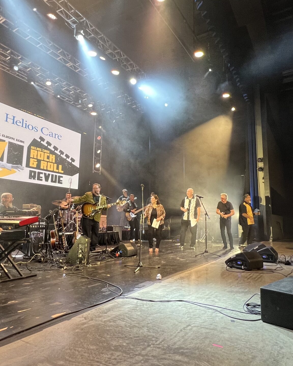 Singers and guitarists standing on stage at concert