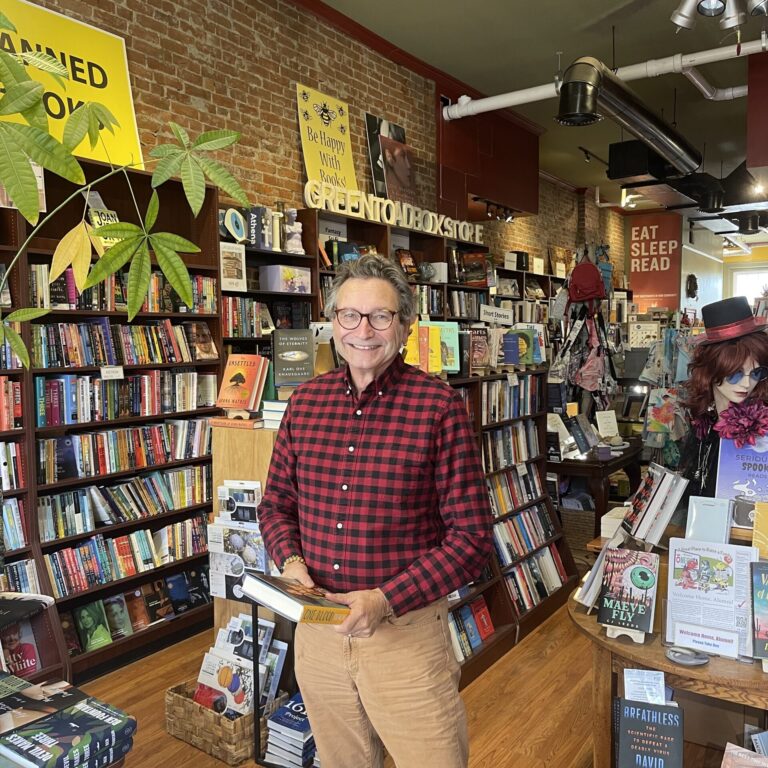 Man holding a book and standing in bookstore
